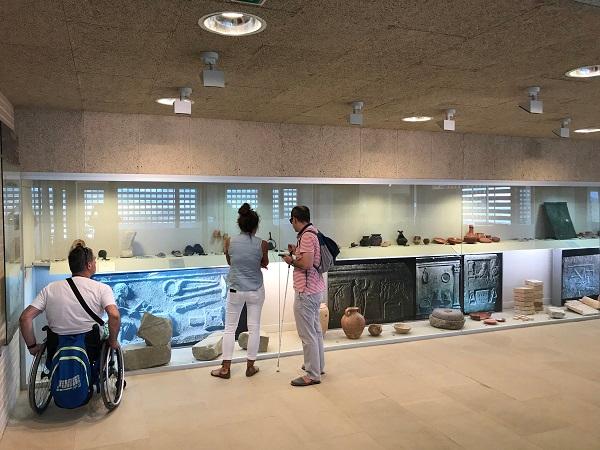Tres personas, una en silla de ruedas y otra invidente, en le museo de Andelos